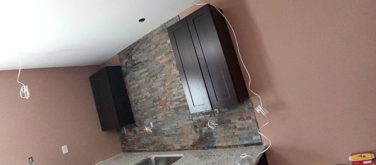 Finished stacked stone feature wall with dark cabinetry