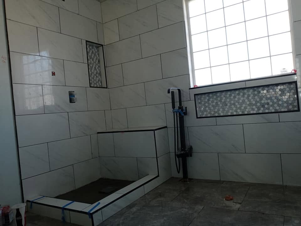 Marble-look shower with hexagon mosaic and recessed shelf
