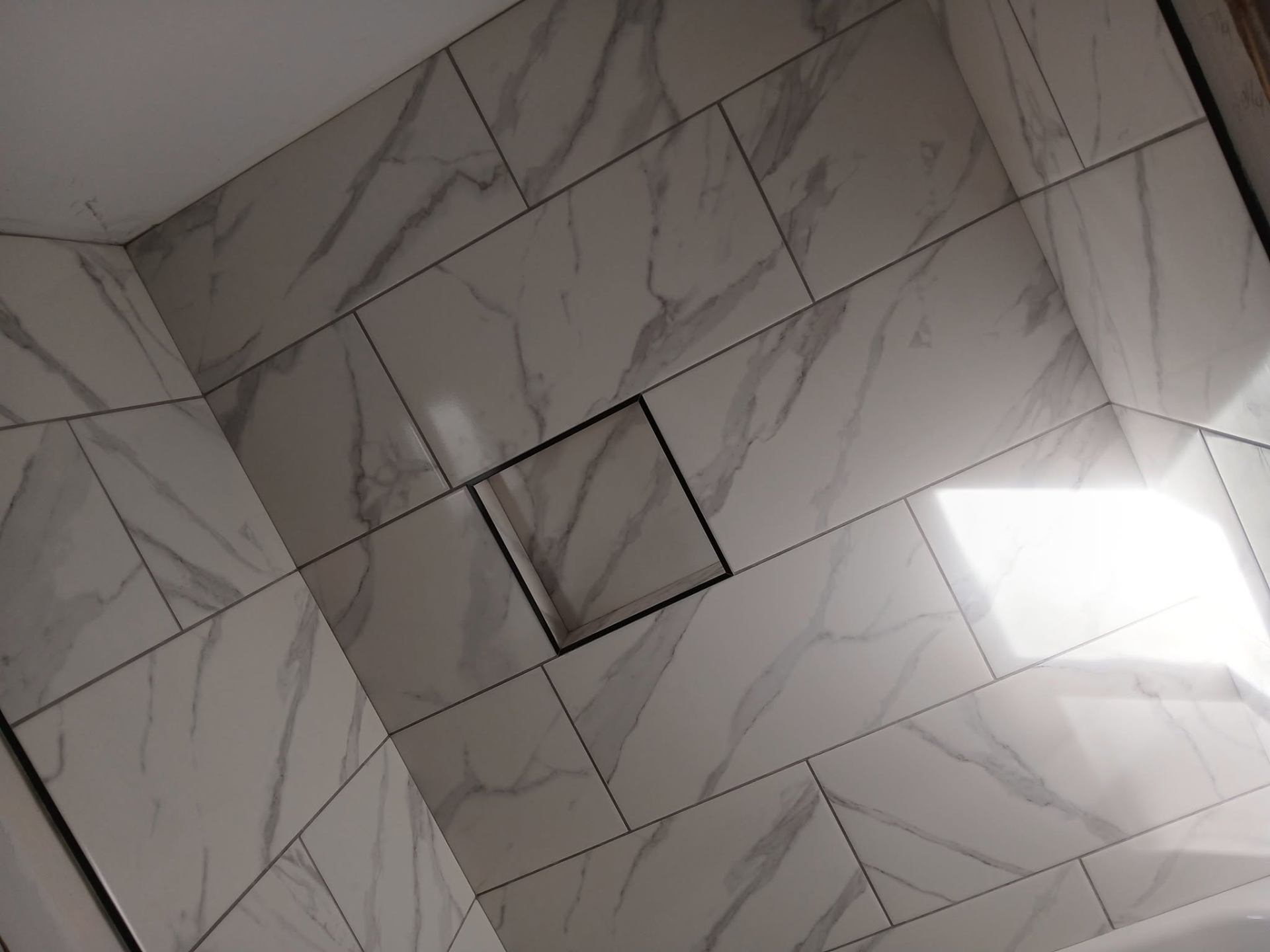 Marble-look large-format shower wall tile with linear drain niche