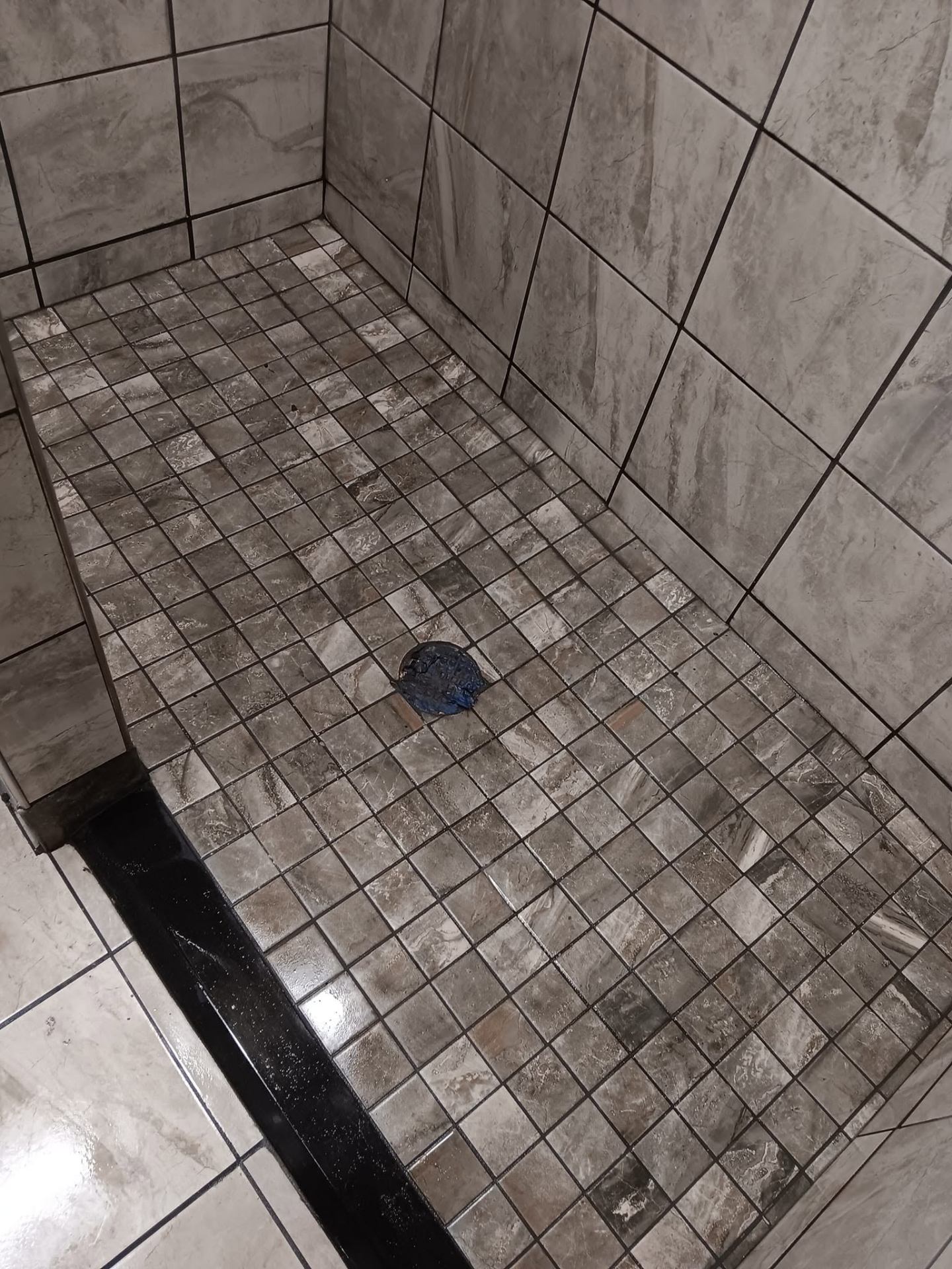 Square mosaic shower floor tile detail with drain
